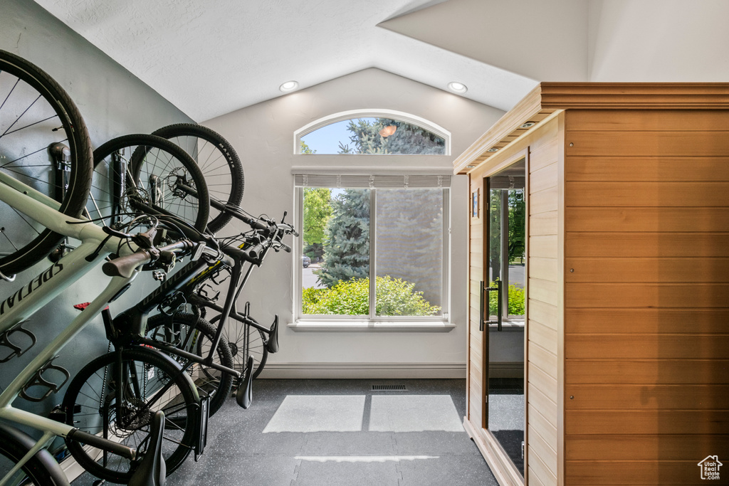 Interior space with baseboards, recessed lighting, lofted ceiling, and visible vents