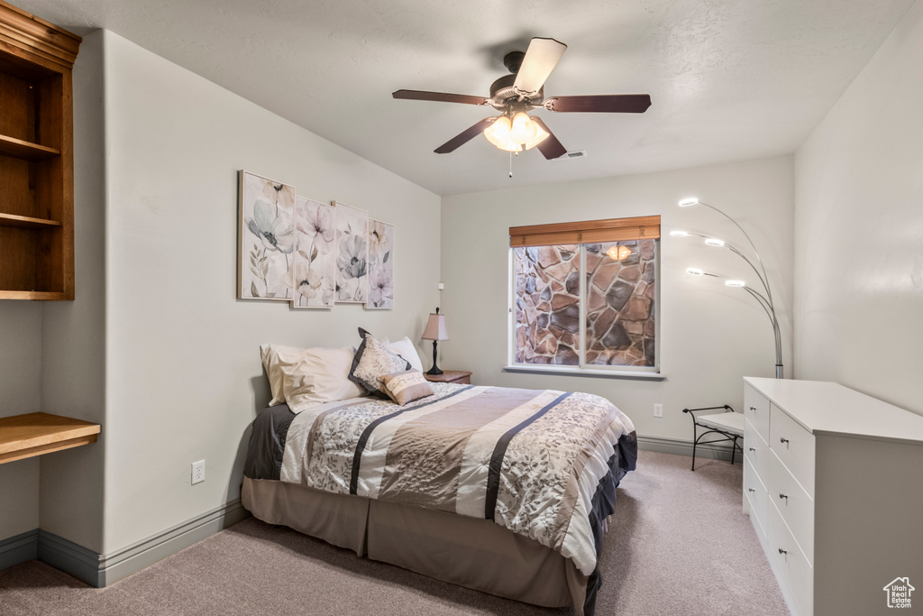 Bedroom featuring carpet floors, baseboards, and ceiling fan
