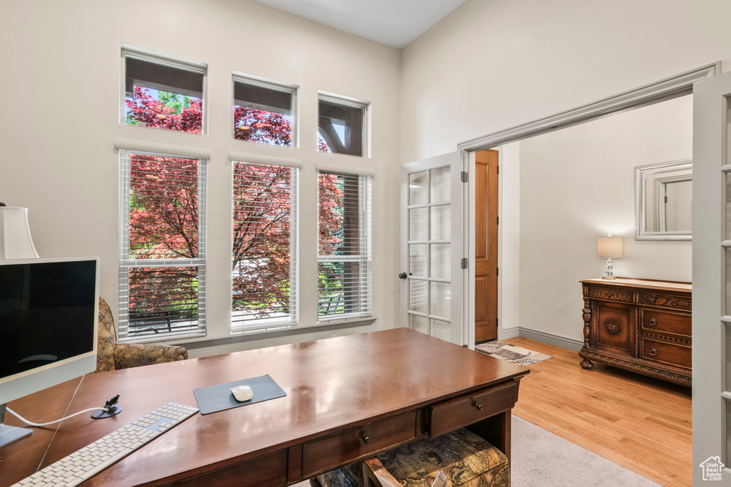 Home office featuring a high ceiling and wood finished floors