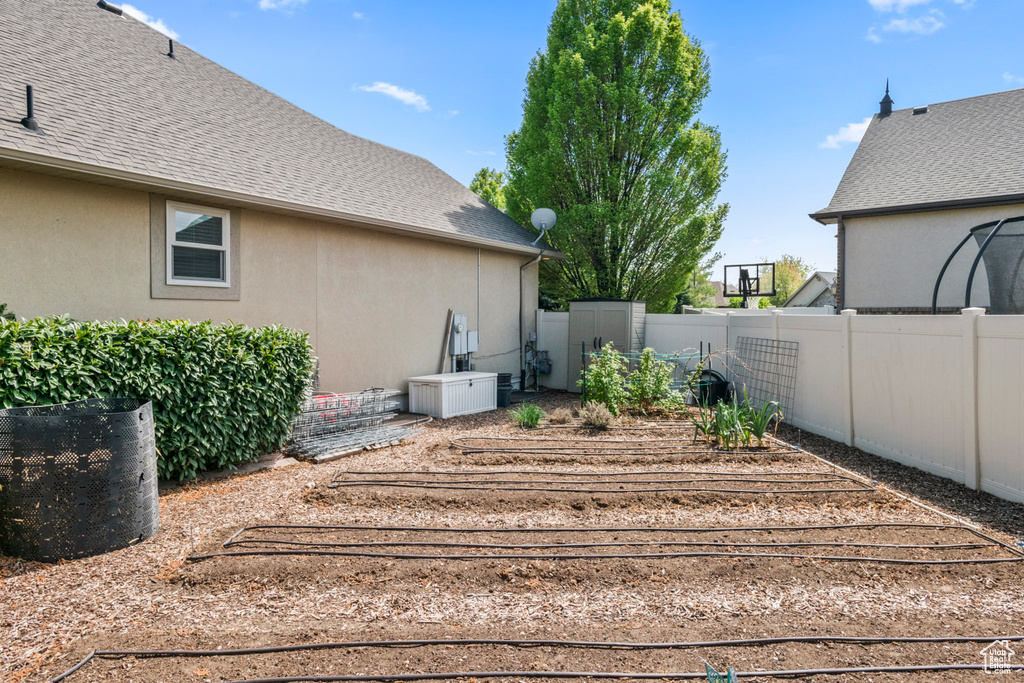 View of yard featuring fence and a vegetable garden