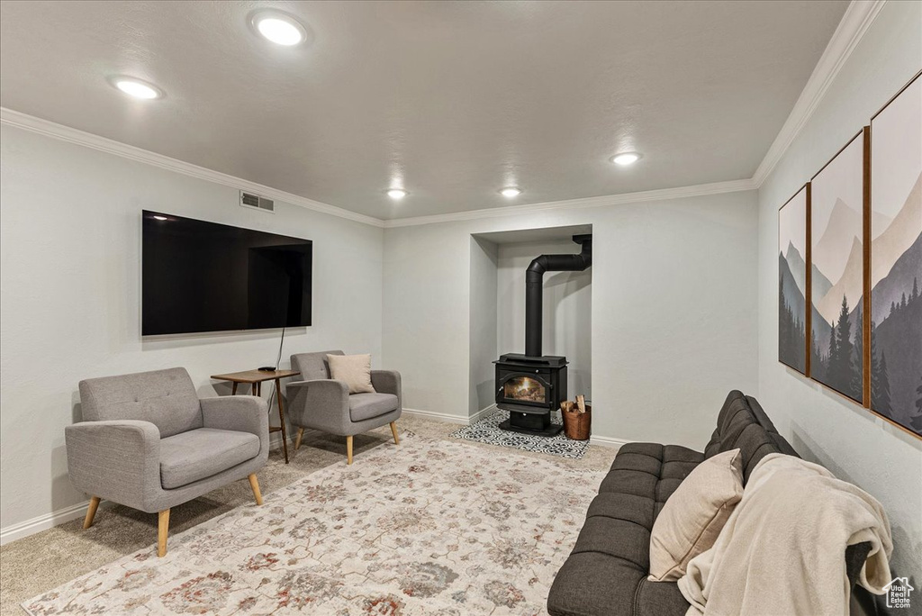 Carpeted living area featuring recessed lighting, baseboards, visible vents, and a wood stove