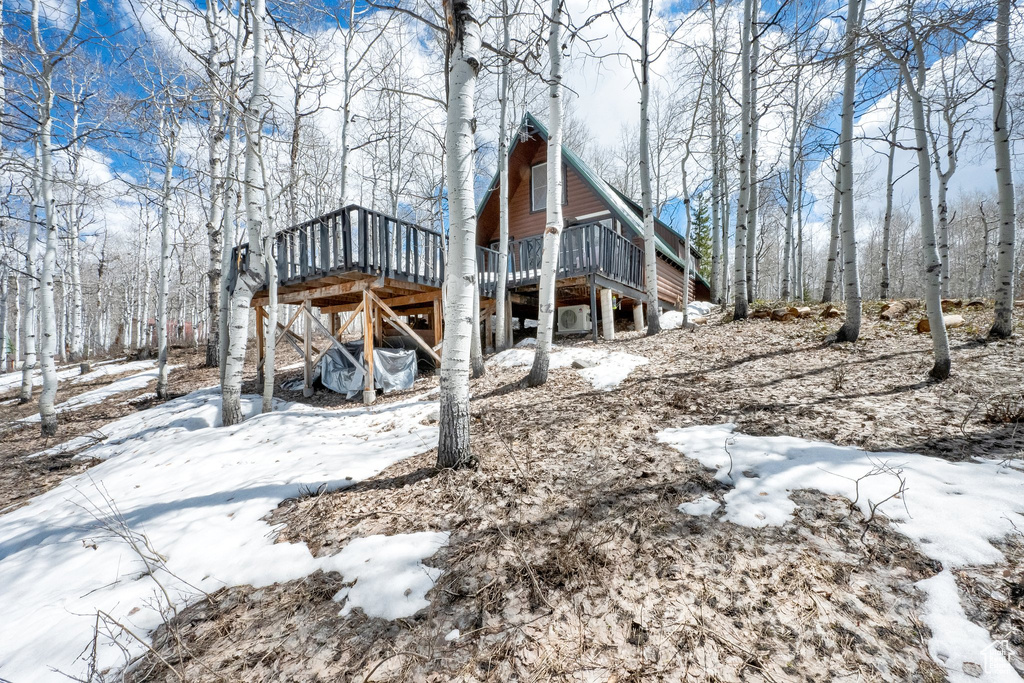 View of snowy exterior with a deck