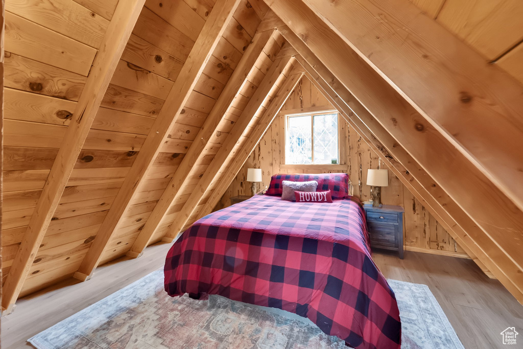 Bedroom featuring wood walls, light wood finished floors, lofted ceiling, and wood ceiling
