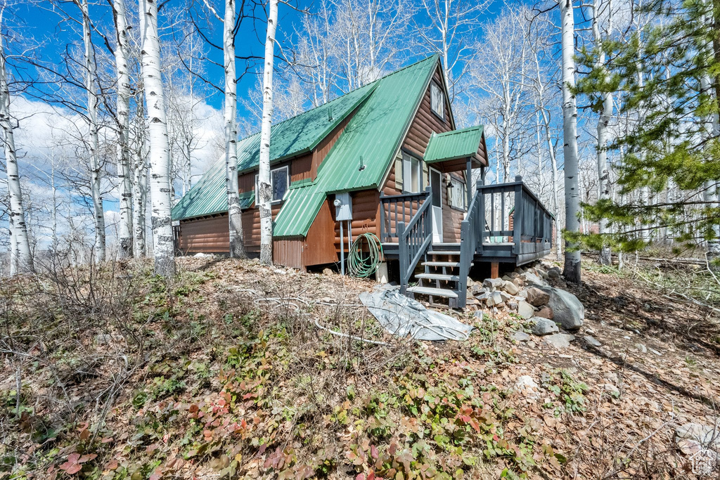 Exterior space featuring a deck, metal roof, and log veneer siding