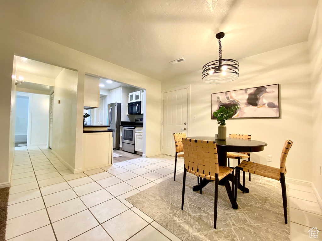 Dining space featuring baseboards, visible vents, and light tile patterned floors