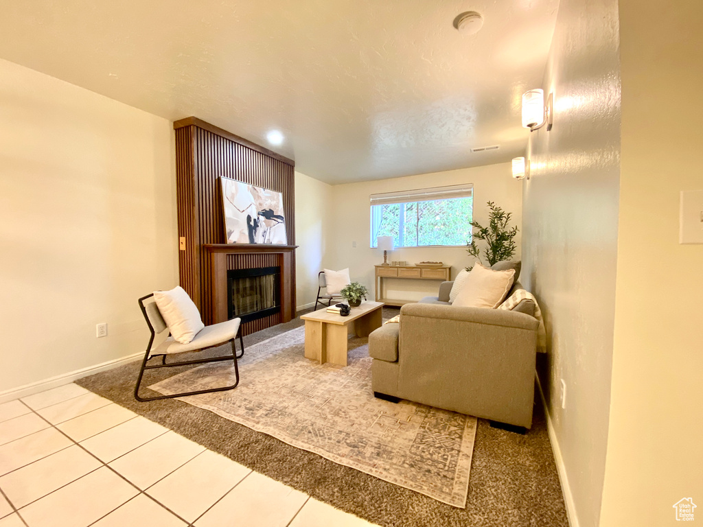 Living area featuring baseboards, tile patterned flooring, and a fireplace