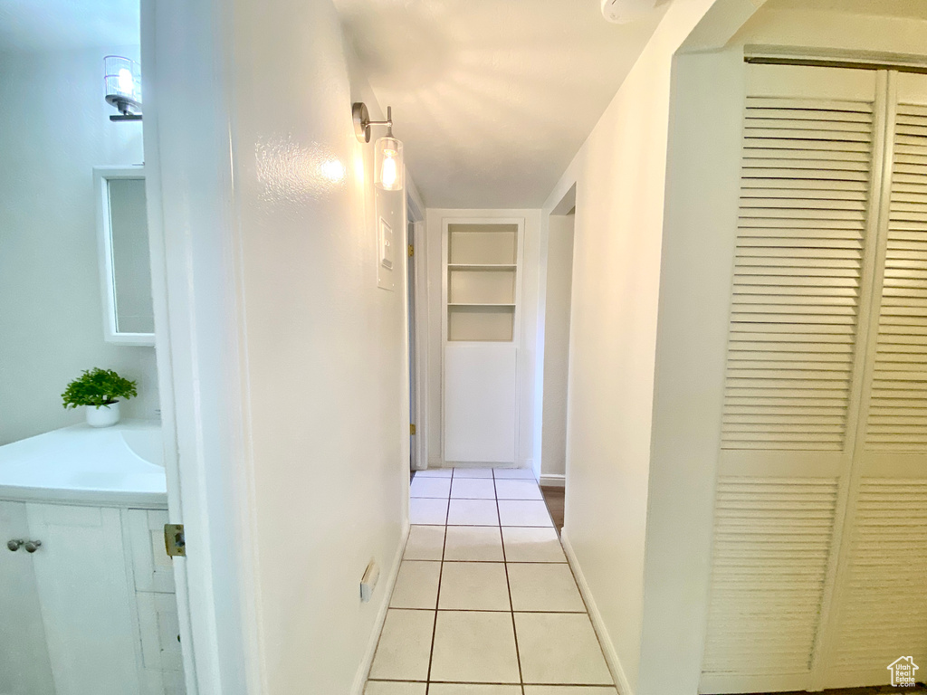 Corridor featuring built in features and tile patterned flooring