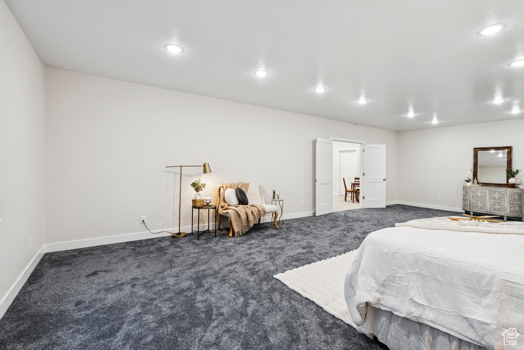 Bedroom with dark carpet, baseboards, and recessed lighting
