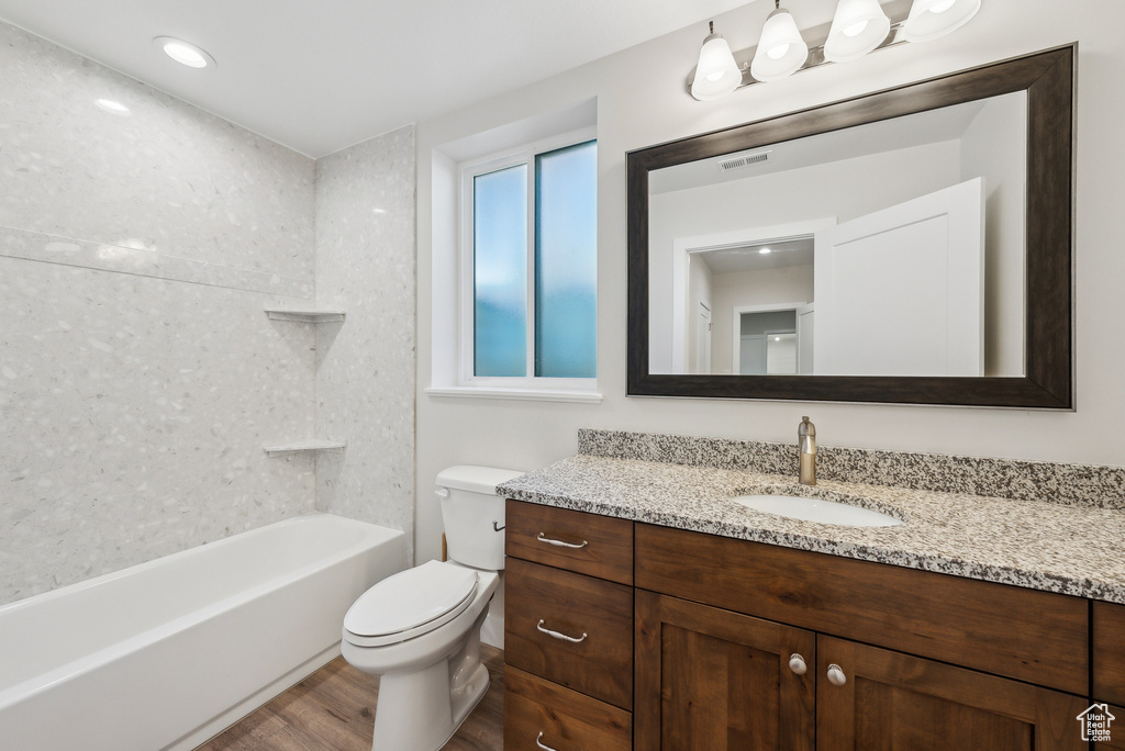 Bathroom featuring visible vents, toilet, vanity, and wood finished floors