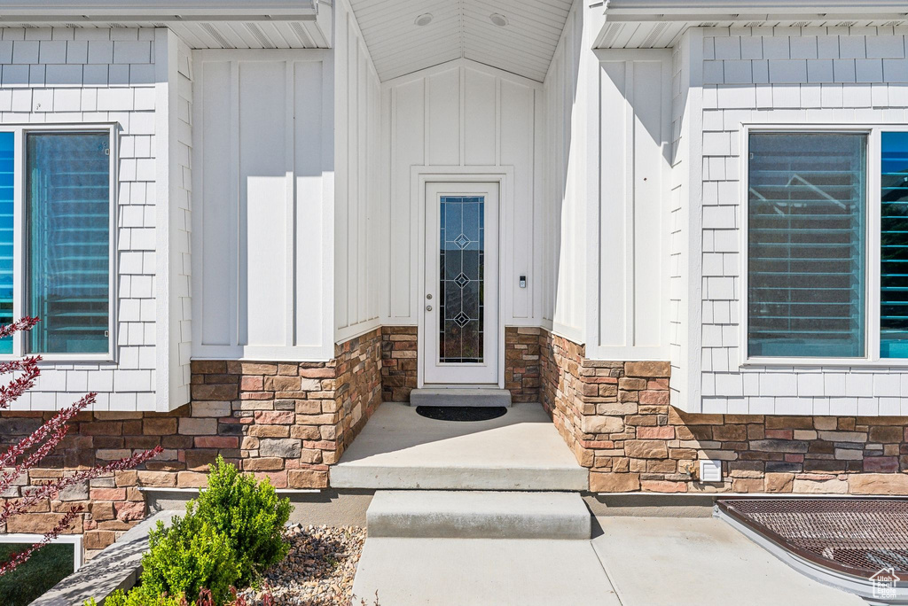 Entrance to property with board and batten siding and stone siding