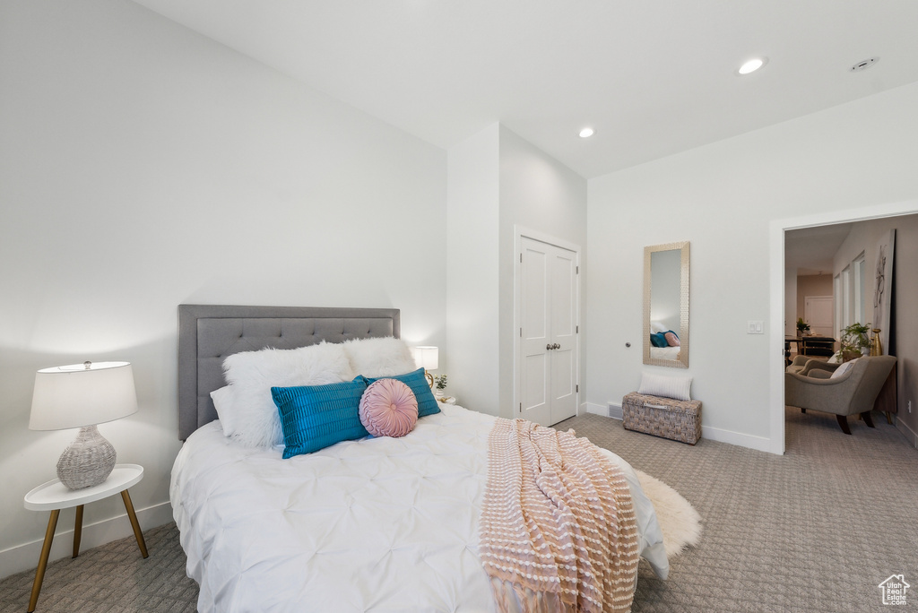 Bedroom with a closet, baseboards, recessed lighting, high vaulted ceiling, and carpet flooring