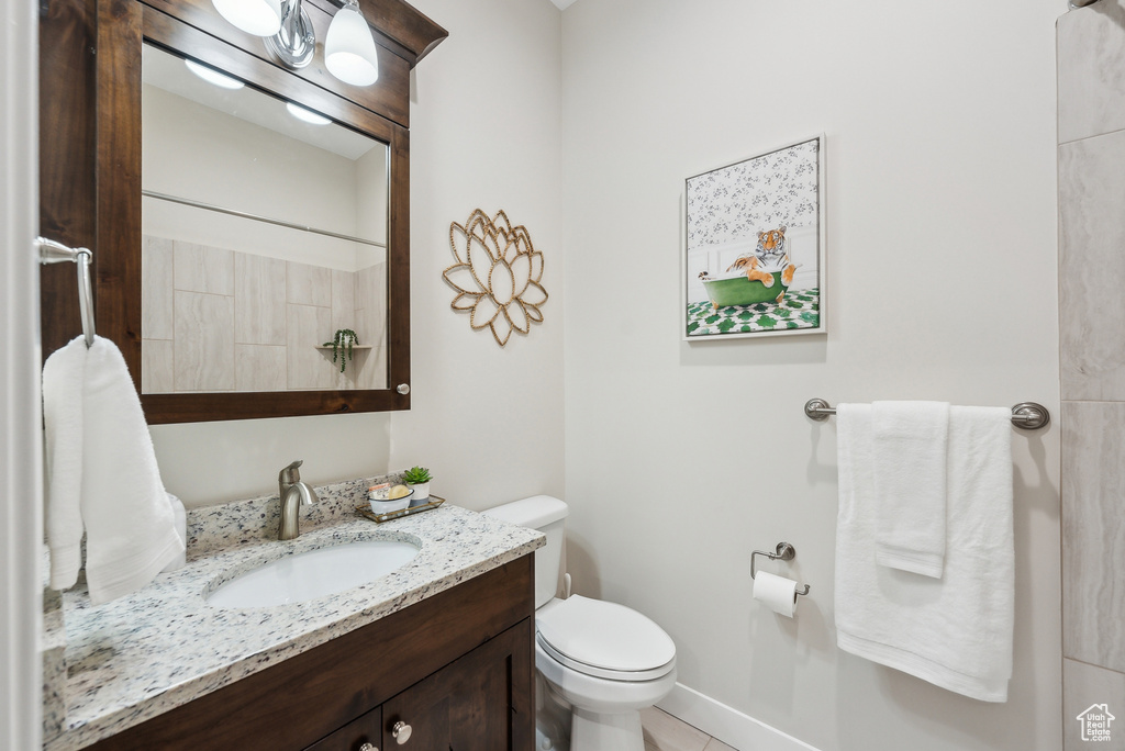 Bathroom featuring toilet, tile patterned floors, and vanity