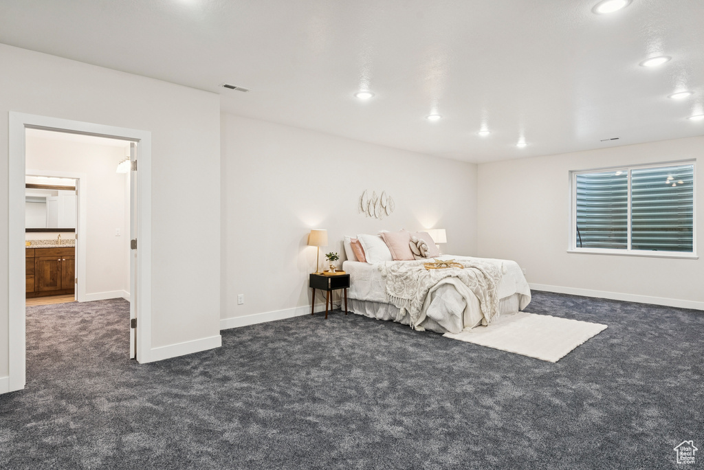 Bedroom with dark colored carpet, recessed lighting, and baseboards