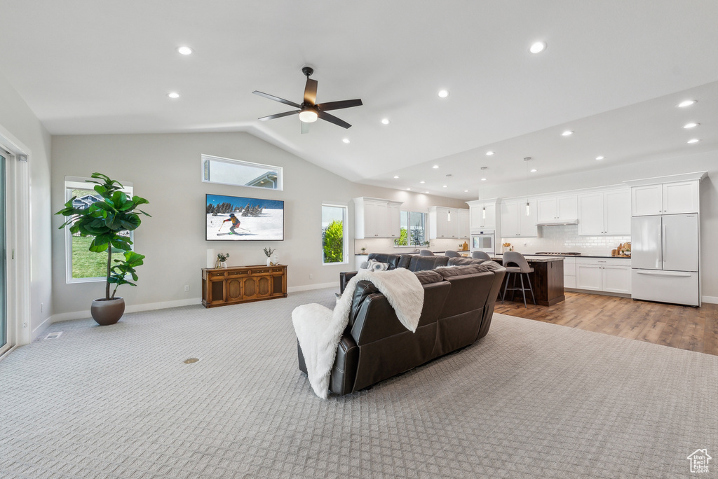 Living area with baseboards, light carpet, recessed lighting, lofted ceiling, and ceiling fan