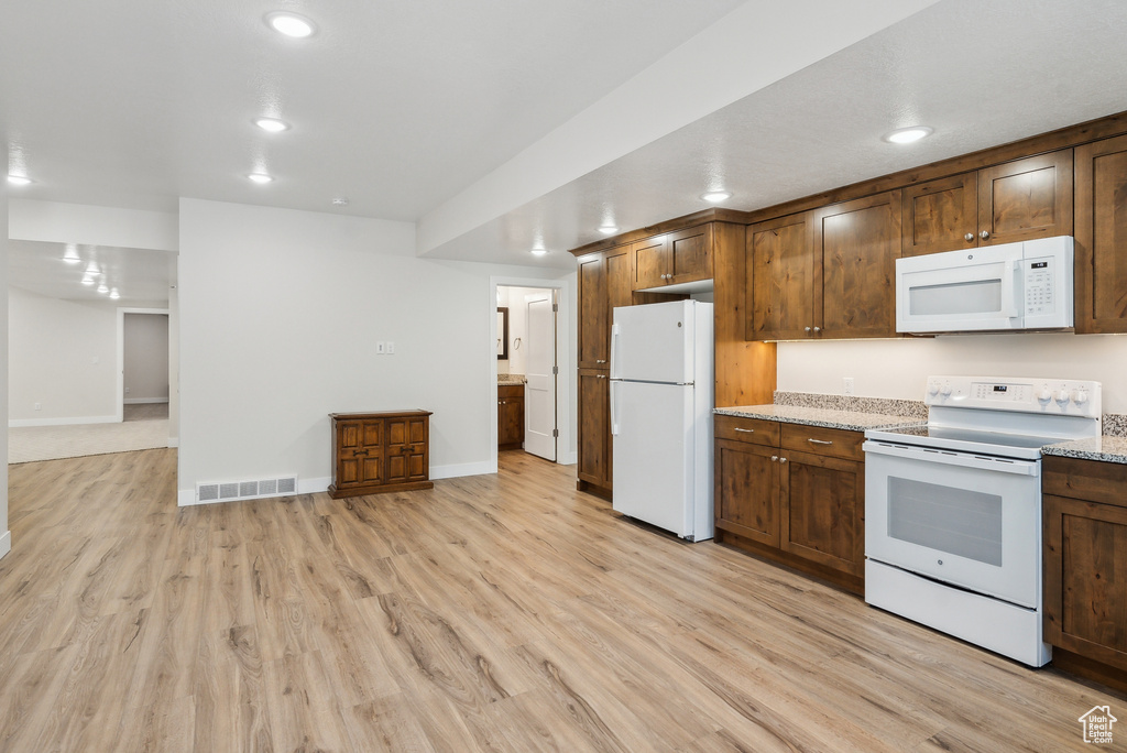 Kitchen featuring recessed lighting, white appliances, visible vents, and light wood finished floors