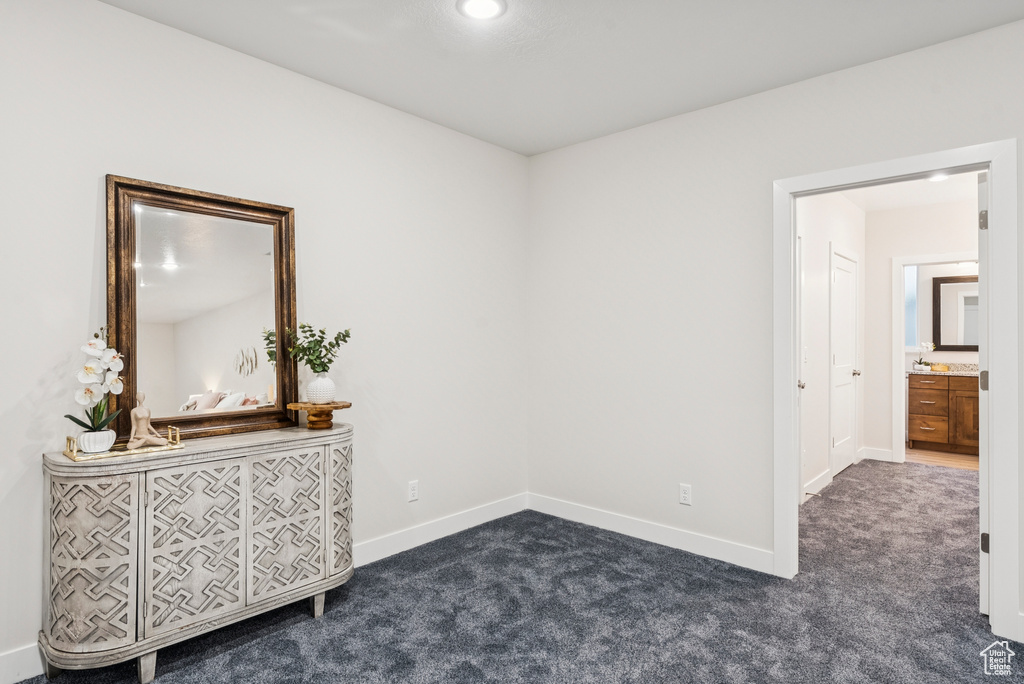 Unfurnished bedroom with dark colored carpet and baseboards