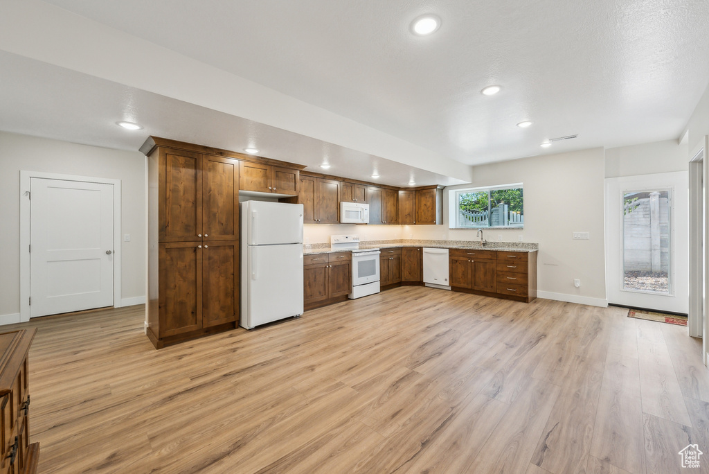 Kitchen featuring white appliances, recessed lighting, a sink, light wood finished floors, and baseboards