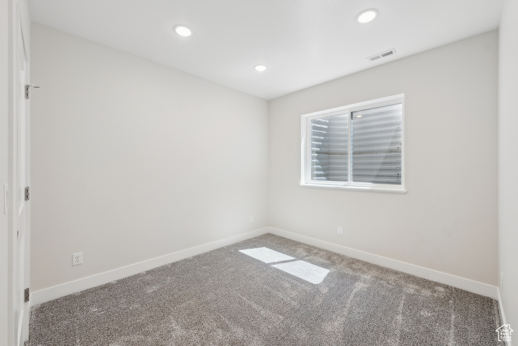 Carpeted spare room with recessed lighting, visible vents, and baseboards