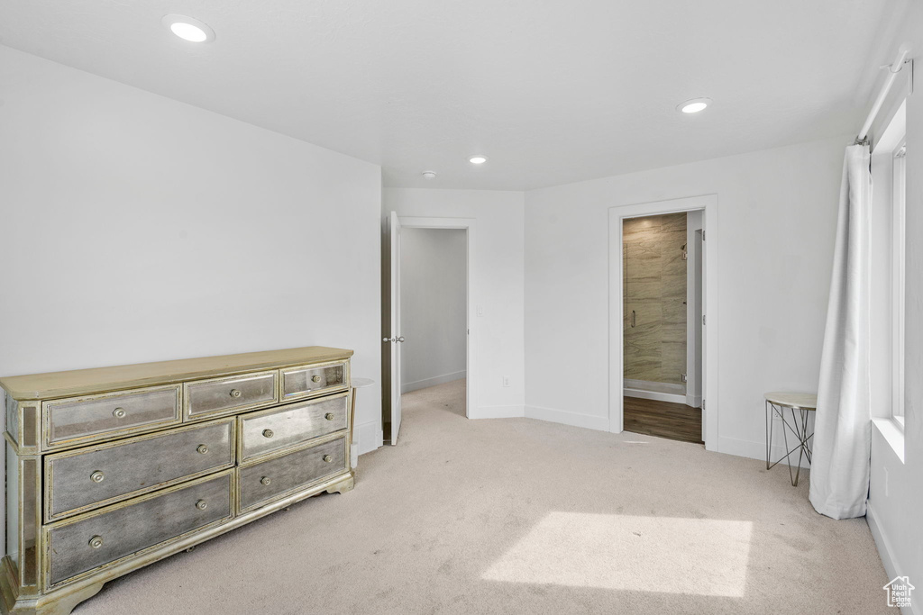 Carpeted bedroom featuring baseboards, recessed lighting, and connected bathroom