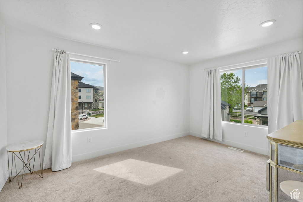 Carpeted empty room with recessed lighting, baseboards, and visible vents