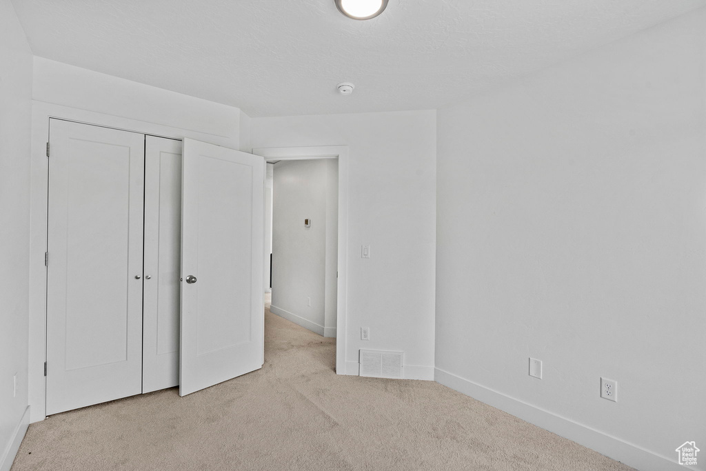 Unfurnished bedroom featuring a closet, baseboards, carpet flooring, and visible vents