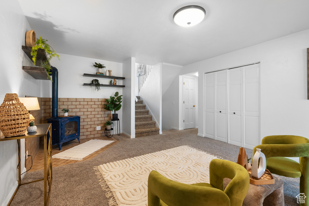 Carpeted living area with a wood stove, baseboards, and stairway