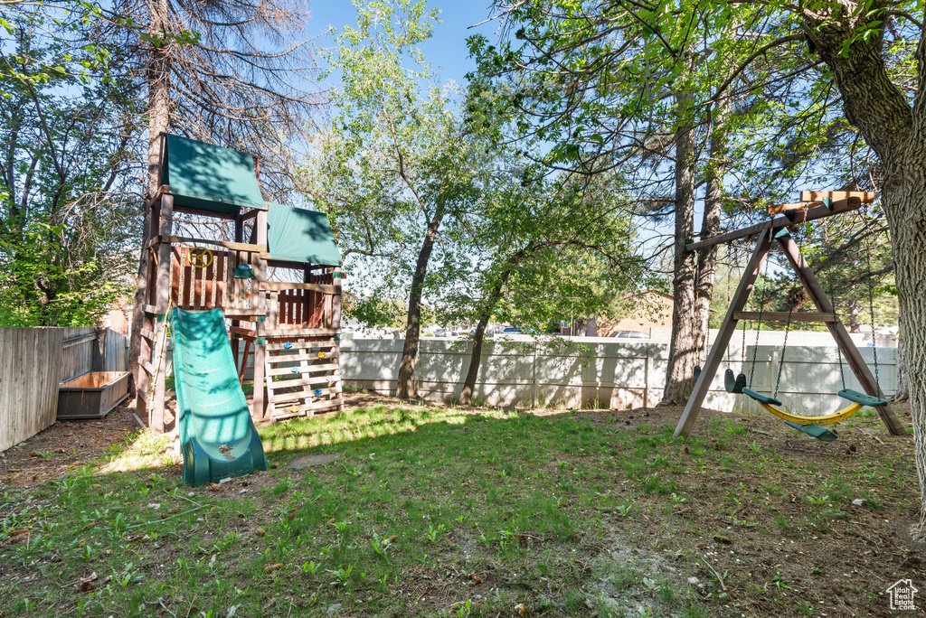 View of yard with a fenced backyard and a playground
