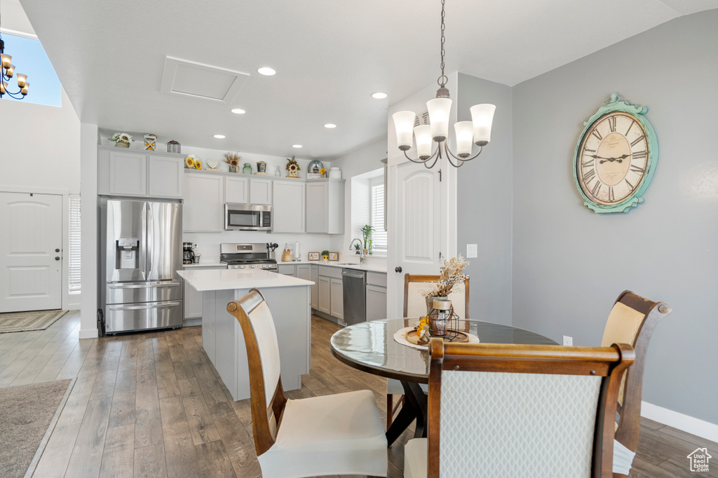Dining room with an inviting chandelier, baseboards, recessed lighting, and wood finished floors