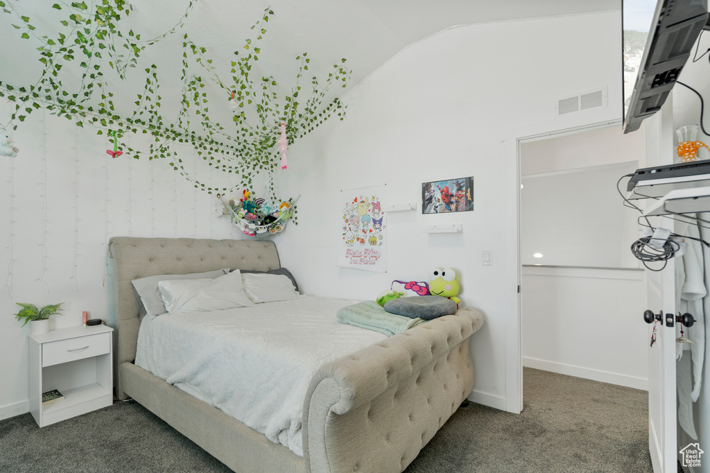Carpeted bedroom featuring baseboards, visible vents, and lofted ceiling