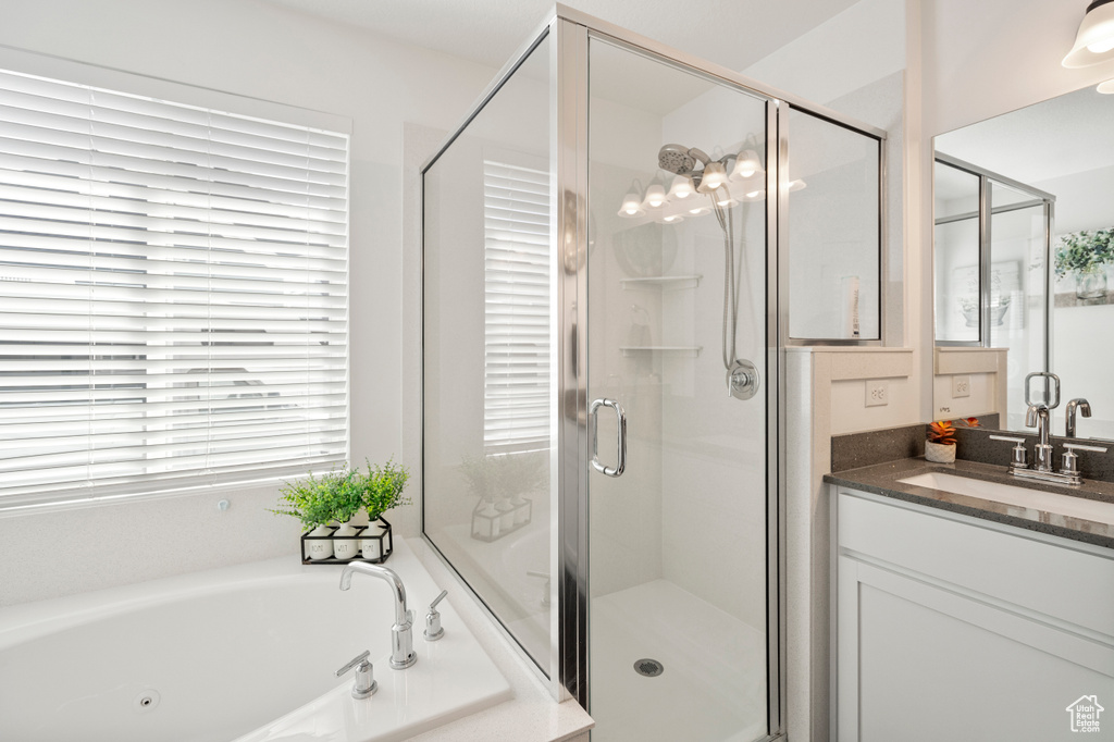 Bathroom with a jetted tub, vanity, and a stall shower