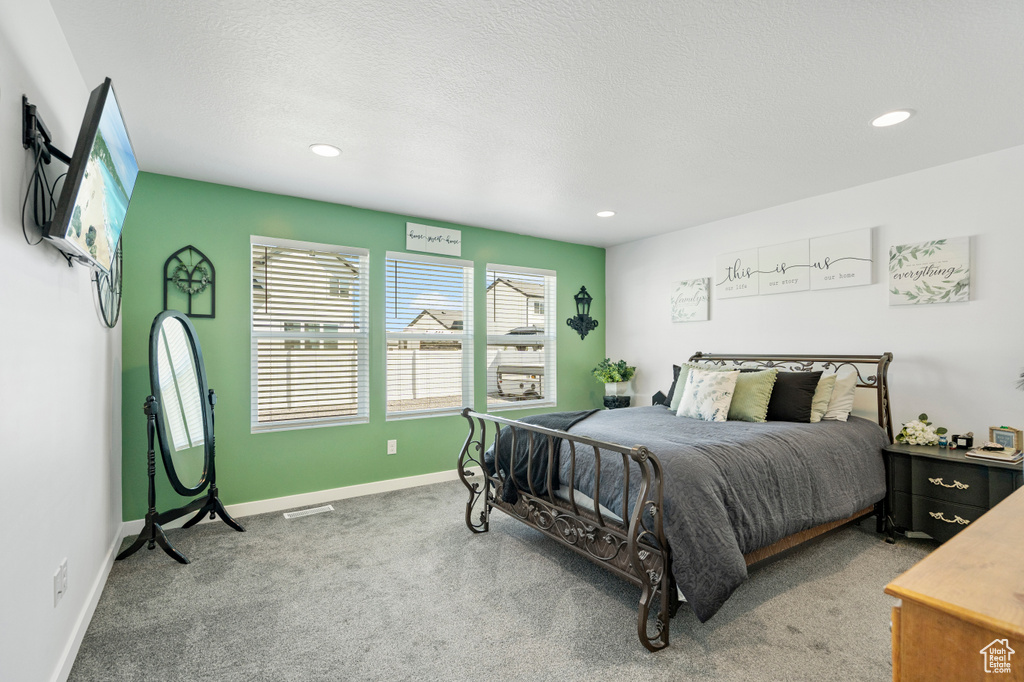 Carpeted bedroom with baseboards, recessed lighting, and visible vents