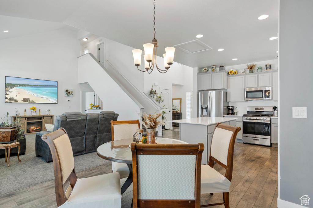 Dining area with recessed lighting, light wood finished floors, and a lit fireplace