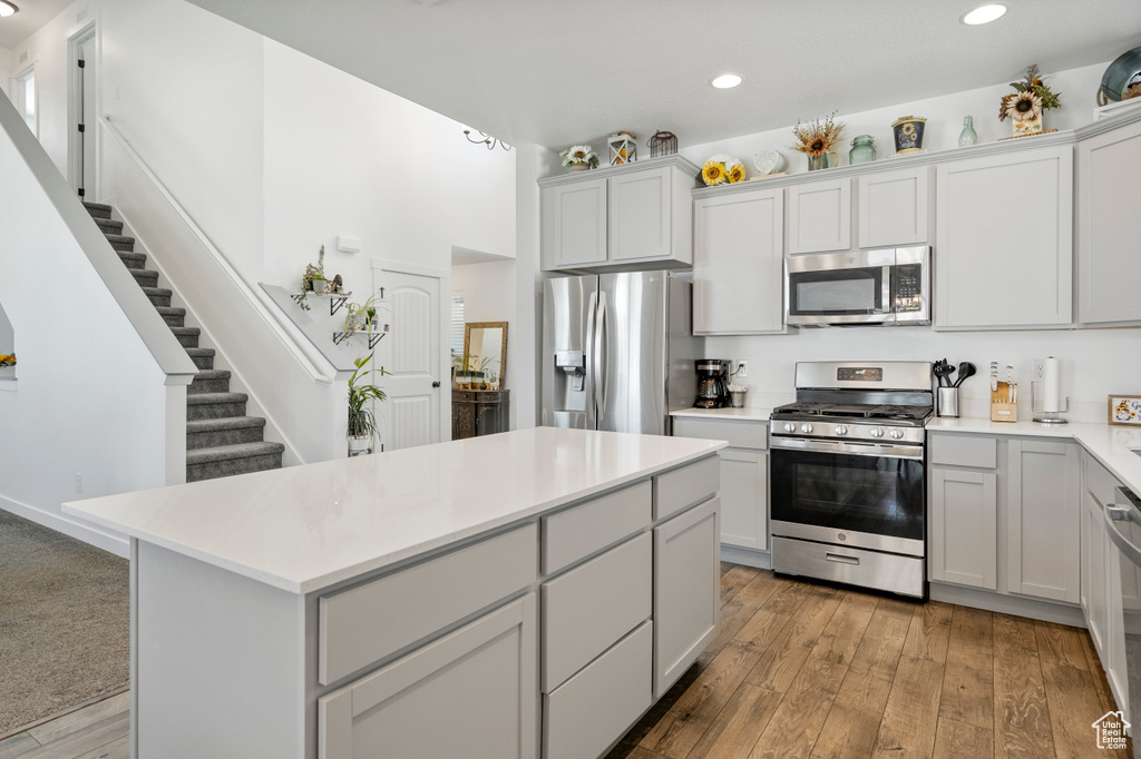 Kitchen featuring light countertops, stainless steel appliances, recessed lighting, and a center island