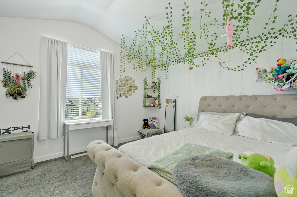 Carpeted bedroom with baseboards and vaulted ceiling