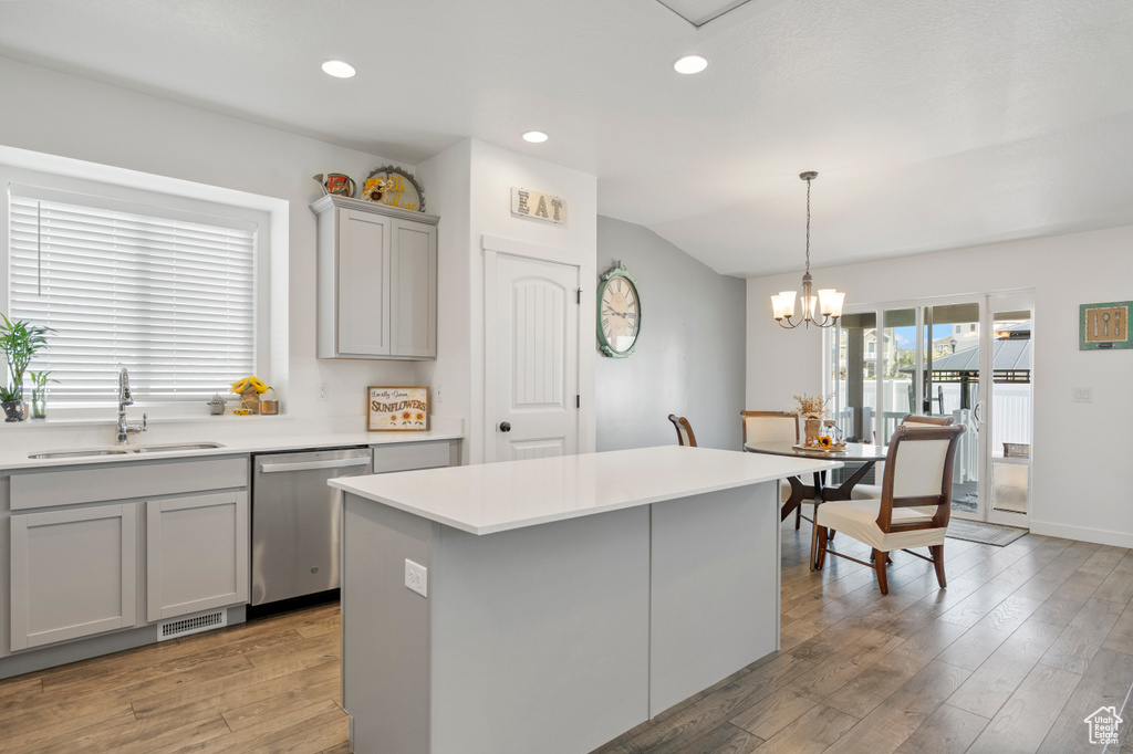 Kitchen featuring stainless steel dishwasher, a sink, light wood-style floors, and gray cabinetry