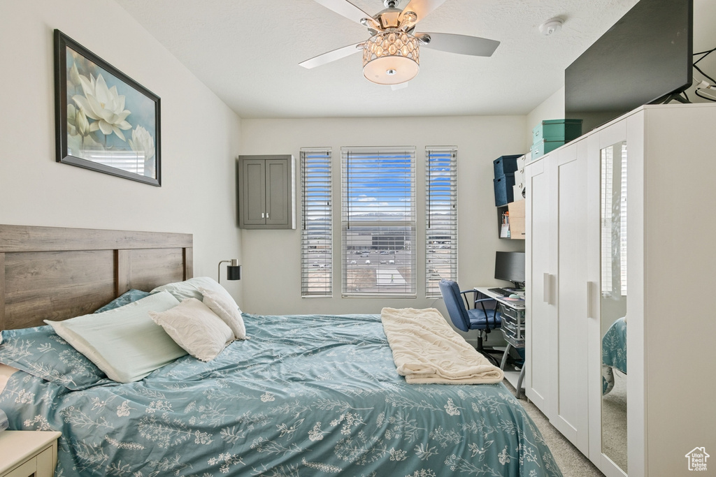 Bedroom with carpet flooring, a desk, and a ceiling fan