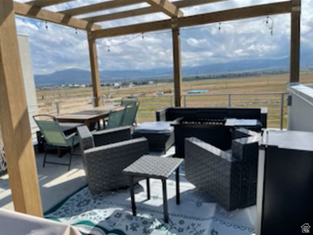 View of patio featuring an outdoor hangout area, a pergola, outdoor dining area, and a rural view