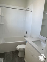 Bathroom with toilet, shower / bath combination, and vanity