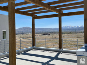 View of patio / terrace featuring a view of countryside, a mountain view, a pergola, and fence