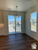 Unfurnished dining area with a chandelier, dark wood-type flooring, and baseboards