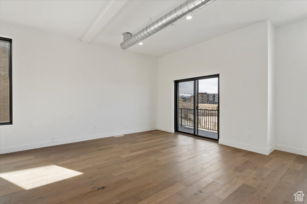 Spare room featuring recessed lighting, baseboards, wood finished floors, and beam ceiling