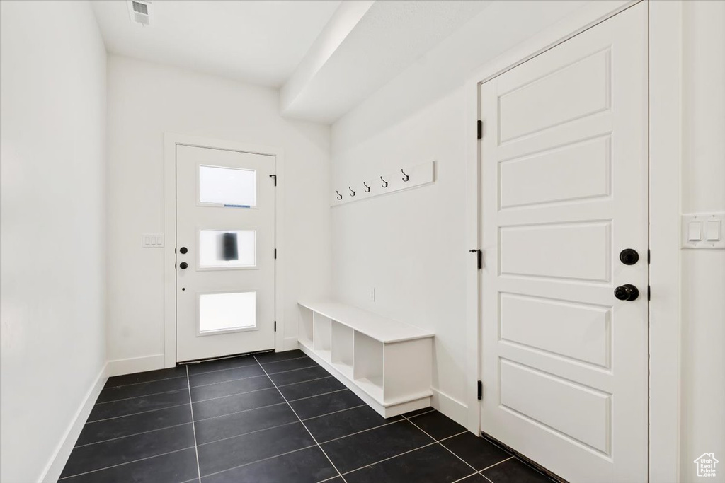 Mudroom with visible vents, baseboards, and dark tile patterned flooring