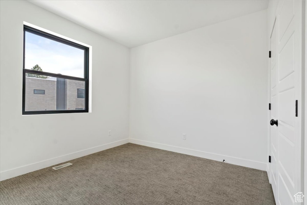 Empty room with baseboards, carpet, and visible vents