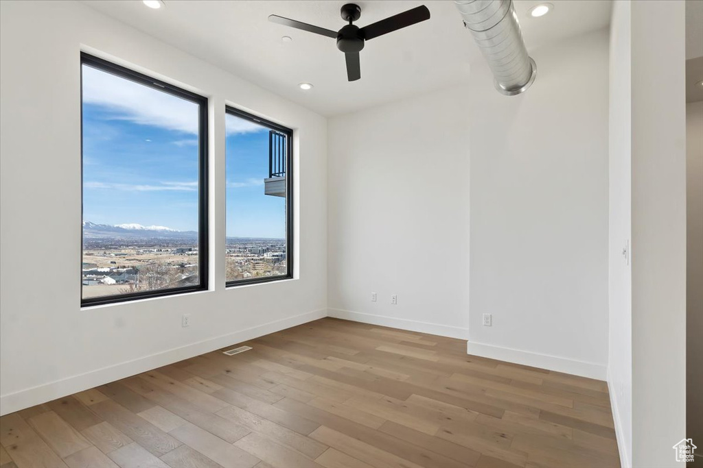 Empty room featuring ceiling fan, recessed lighting, baseboards, visible vents, and hardwood / wood-style flooring