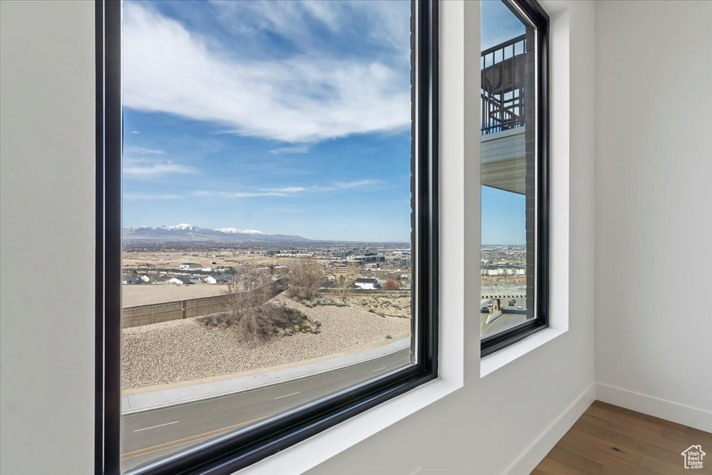 Room details featuring baseboards, a mountain view, and wood finished floors