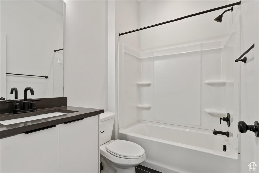 Bathroom with toilet, shower / tub combination, and vanity