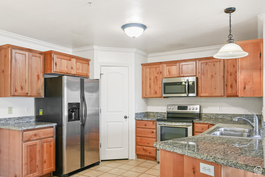 Kitchen with crown molding, pendant lighting, a sink, stainless steel appliances, and light tile patterned flooring
