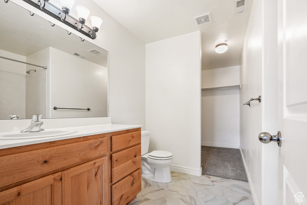 Full bath with visible vents, marble finish floor, toilet, and vanity