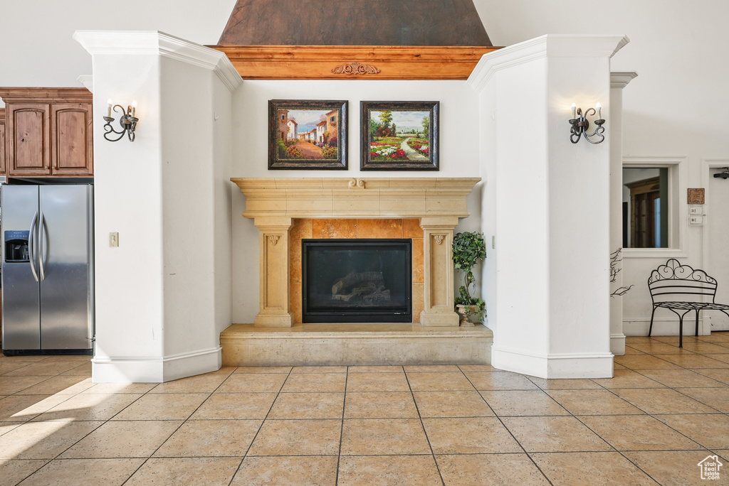 Unfurnished living room with baseboards, a high end fireplace, and light tile patterned flooring
