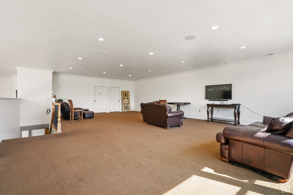 Living room with crown molding, recessed lighting, and carpet floors